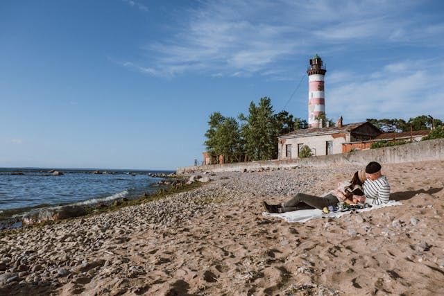 Couple laying down on a beach reading