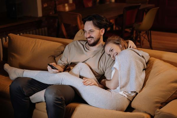 young couple happy on couch watching television