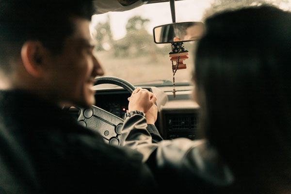 couple in car holding hands looking happy