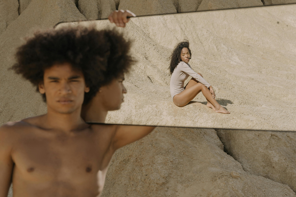 Man and woman looking in mirror in desert