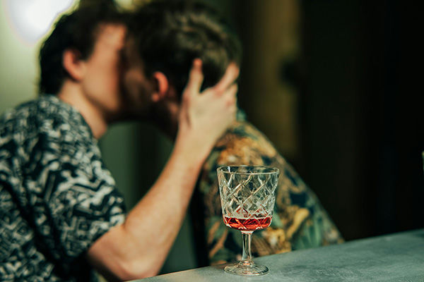 two men kissing at a bar