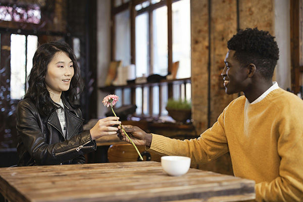 Sexual compatibility young couple sitting at table with flowers